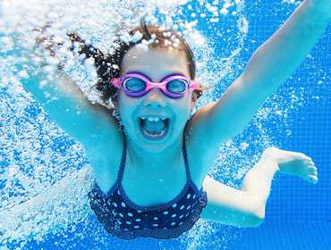 Girl jumping into the pool built by pool experts and fiberglass pool installers, River Rock Pools Tulsa