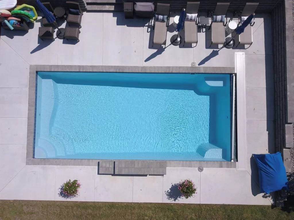 004. R32 pool in Caribbean with paver coping and brushed concrete decking featuring a cascade water feature-2